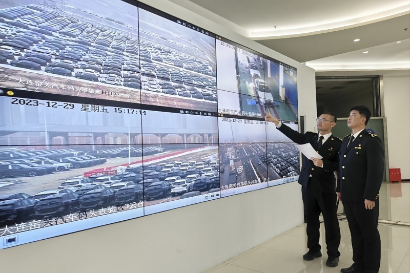 海關(guān)關(guān)員視頻巡查出口汽車場地。李進(jìn)攝
