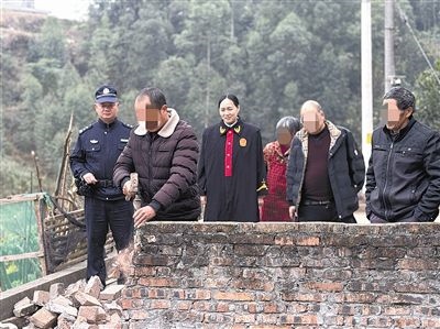  圖③：庭審結(jié)束后，在法官的見證下，陳某在院壩邊重新開鑿一條通道。
