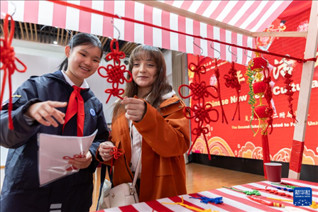 1月28日，復(fù)旦大學(xué)第二附屬學(xué)校學(xué)生（左）為美國馬斯卡廷中學(xué)學(xué)生（右）介紹中國結(jié)。 新華社記者 王翔 攝