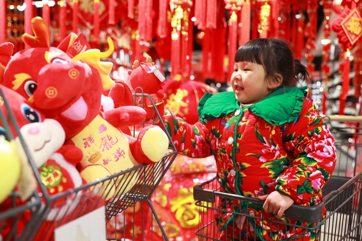 1月23日，在貴州省黔東南苗族侗族自治州岑鞏縣一家超市，小朋友在家人的帶領(lǐng)下選購龍年毛絨玩具。新華社發(fā)（唐鵬攝）