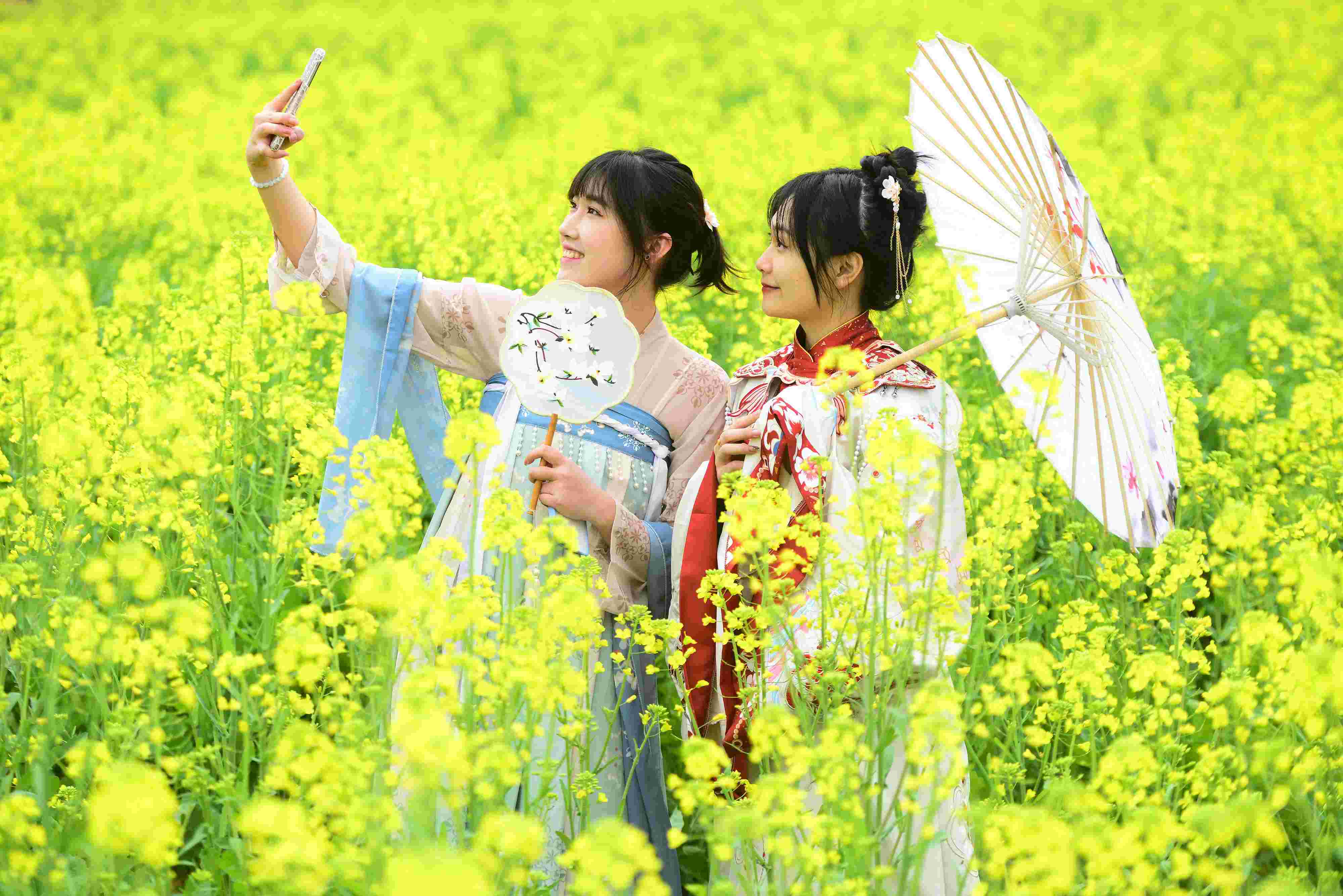 △ 2024年2月16日，廣西賀州，在富川瑤族自治縣麥嶺鎮(zhèn)三民村，游客在油菜花田間賞花拍照。