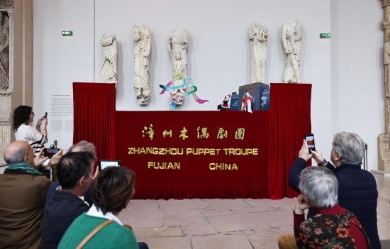 2月10日，在位于法國(guó)巴黎埃菲爾鐵塔附近的“建筑與遺產(chǎn)之城”博物館，觀眾欣賞漳州布袋木偶戲。新華社記者高靜攝