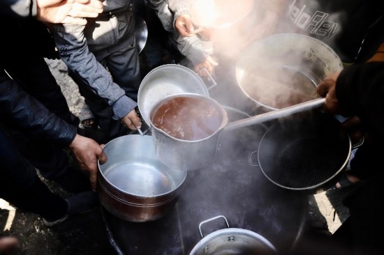  2月27日，在加沙地帶北部的杰巴利耶難民營(yíng)，人們領(lǐng)取食物。新華社發(fā)（穆罕默德·阿里攝）
