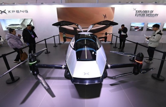 2023年12月1日，在鏈博會智能汽車鏈展區(qū)小鵬汽車展臺，參觀者觀看一臺智能飛行器。新華社記者蔡湘鑫攝