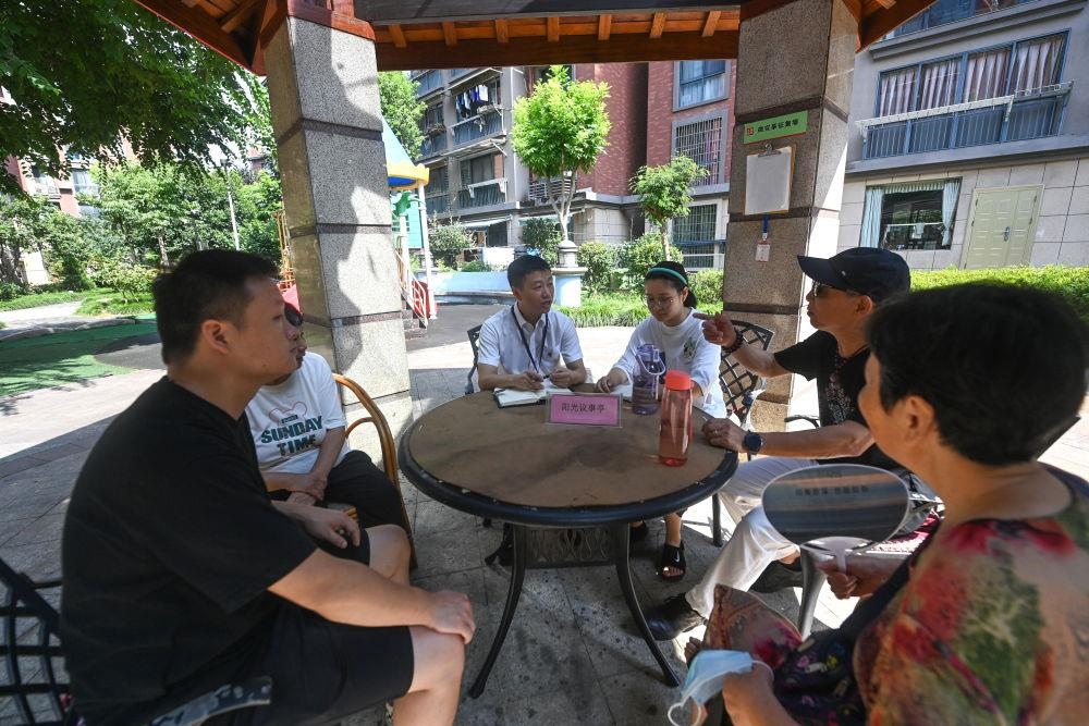 △2023年7月21日，在位于浙江杭州臨安區(qū)錦南街道水岸陽光小區(qū)的陽光議事廳，街道干部在聽取居民們反映的問題及意見。