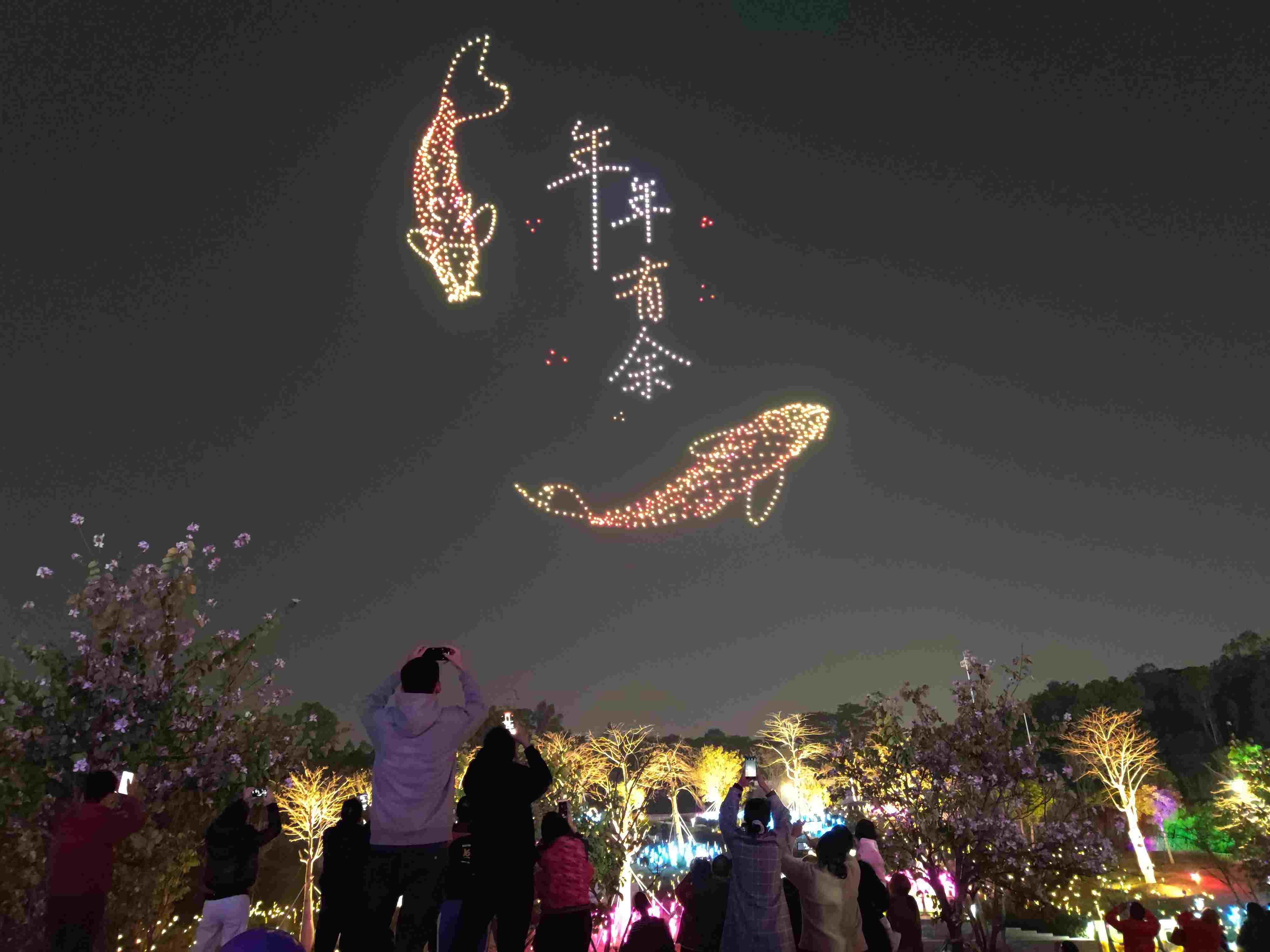 △ 2024年2月10日，深圳北站中心公園，春節(jié)主題無人機(jī)燈光秀引來眾多游客駐足觀看。