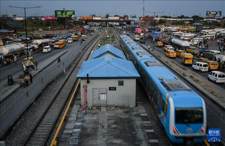 3月4日，在尼日利亞拉各斯，一列輕軌藍(lán)線列車行駛至公路交通擁堵路段附近。新華社記者 韓旭 攝