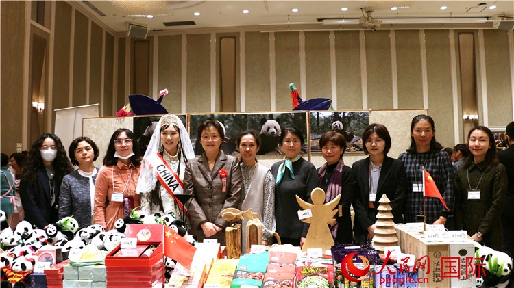 中國(guó)駐日本大使吳江浩夫人丁玥（左五）與使館人員在展位前合影留念。人民網(wǎng) 許可攝