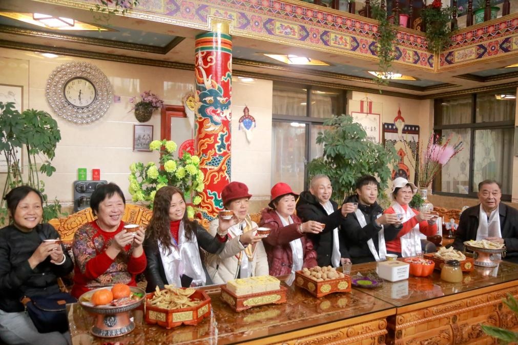 游客們?nèi)胱∶袼藓?，舉杯共飲酥油茶。新華社記者 邱星翔 攝