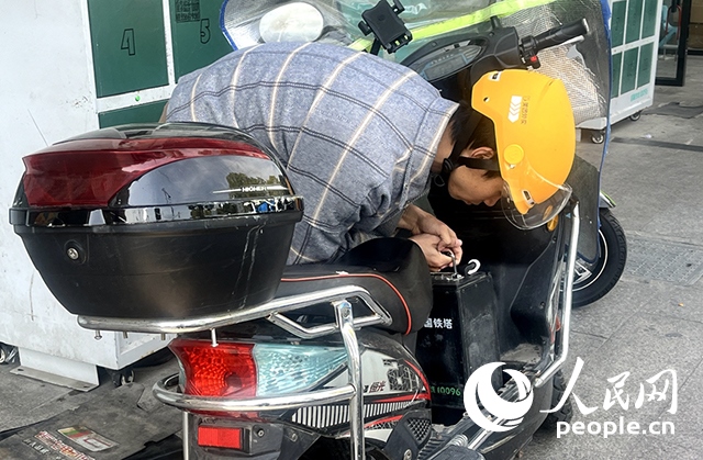 杭州一名外賣騎手正在更換共享電池。人民網(wǎng)記者 張麗瑋攝