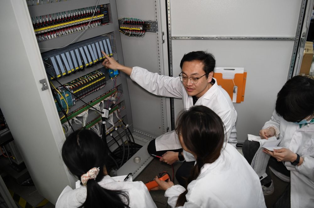 2024年4月6日，在位于安徽合肥的中國科學(xué)技術(shù)大學(xué)，安徽省先進功能高分子薄膜工程實驗室團隊成員在檢修自主研制的高分子薄膜原位雙向拉伸實驗設(shè)備的電氣控制系統(tǒng)。
