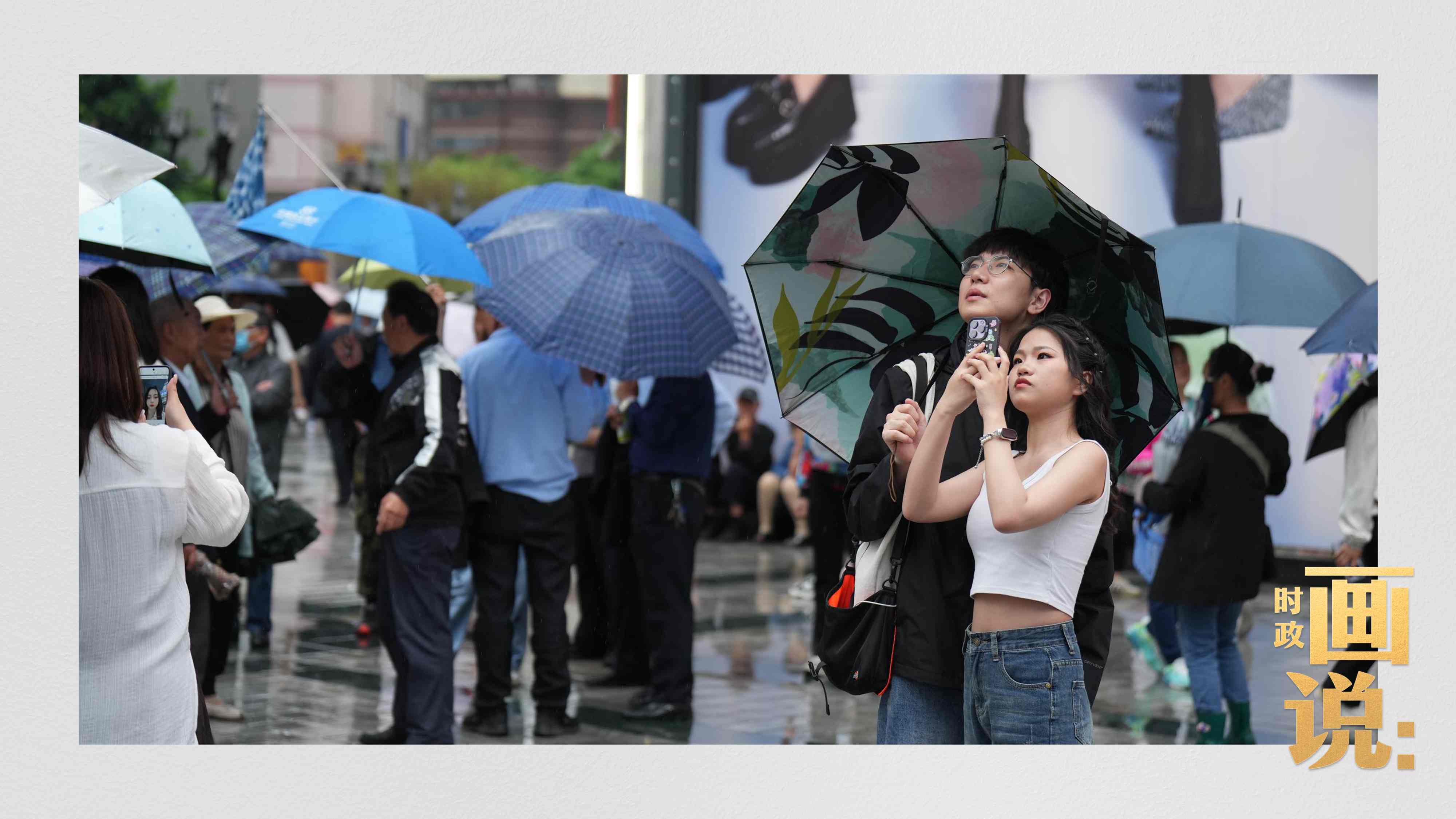△細(xì)雨中的解放碑步行街，騎在父親肩膀的小女孩好奇張望。