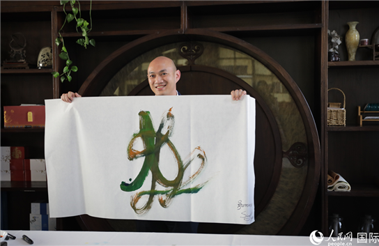 老撾駐華大使館三秘明君參加《五百筆·瀾湄合作》集體藝術(shù)創(chuàng)作。人民網(wǎng)王婧攝。