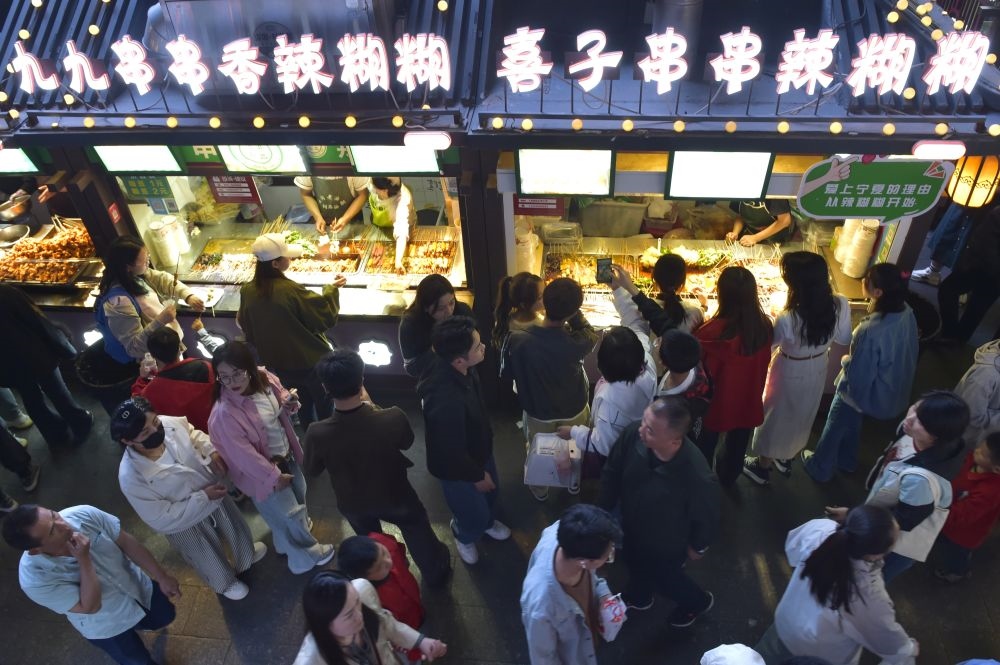 2024年5月4日，游客在寧夏銀川懷遠(yuǎn)夜市品嘗當(dāng)?shù)鼐W(wǎng)紅美食辣糊糊。新華社記者 毛竹 攝