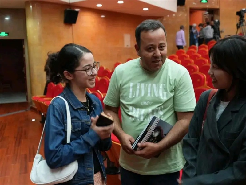 阿爾及利亞市民拉納·艾薩尼和她父親現(xiàn)場聆聽中阿交響樂演出 。蘇州交響樂團(tuán)供圖
