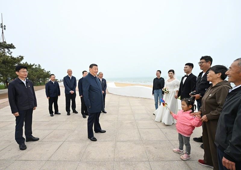 5月22日，在山東日照考察調(diào)研的習(xí)近平總書記來到陽光海岸綠道，同市民游客親切交流。