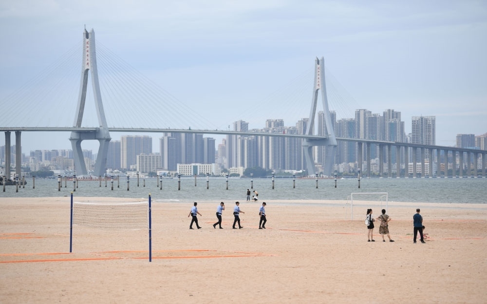 2023年7月17日，廣東湛江五環(huán)廣場(chǎng)的沙灘上，公安民警在執(zhí)勤巡邏。新華社記者 鄧華 攝