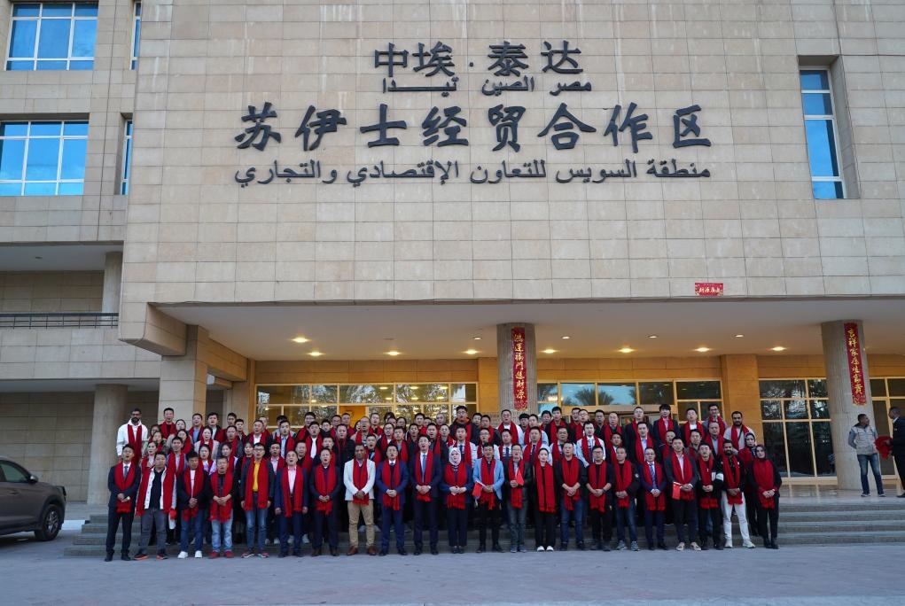 2024年2月11日，在位于埃及蘇伊士省的中?！ぬ┻_(dá)蘇伊士經(jīng)貿(mào)合作區(qū)，中埃員工在合作區(qū)辦公大樓前合影拜年。新華社發(fā)（泰達(dá)合作區(qū)供圖）