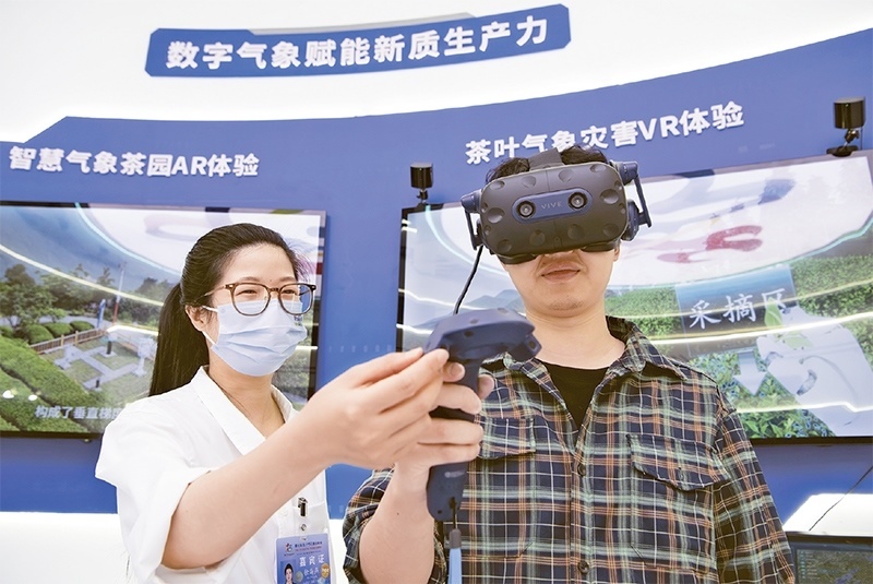 2024年5月23日，第七屆數(shù)字中國(guó)建設(shè)峰會(huì)現(xiàn)場(chǎng)體驗(yàn)區(qū)在福州海峽國(guó)際會(huì)展中心向?qū)I(yè)觀(guān)眾開(kāi)放。本次現(xiàn)場(chǎng)體驗(yàn)區(qū)圍繞本屆峰會(huì)主題“釋放數(shù)據(jù)要素價(jià)值，發(fā)展新質(zhì)生產(chǎn)力”，設(shè)置“數(shù)字惠民”、“數(shù)字能力”、“數(shù)字基礎(chǔ)”、“數(shù)字生態(tài)”、“數(shù)字賦能”五大板塊。圖為一名觀(guān)眾（右）在數(shù)字氣象賦能新質(zhì)生產(chǎn)力展臺(tái)上進(jìn)行體驗(yàn)。 新華社記者 魏培全/攝