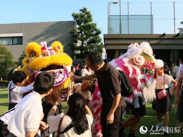 孩子們好奇地圍觀舞獅。人民網(wǎng) 許可攝