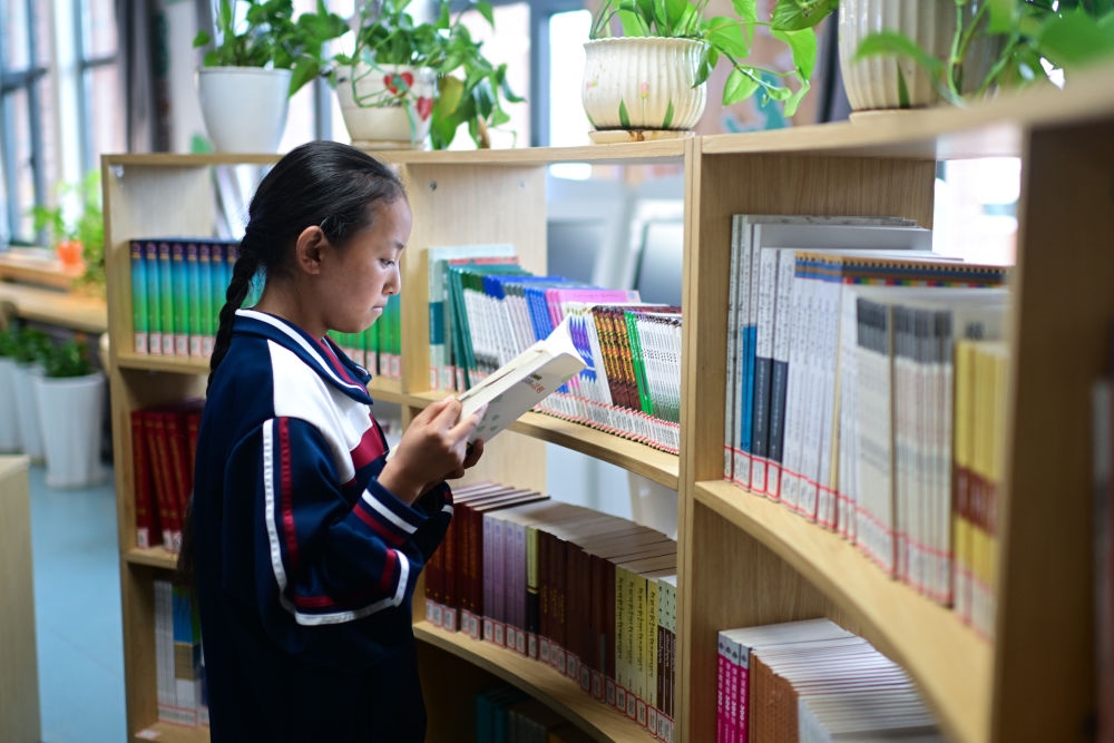 6月18日，果洛西寧民族中學(xué)學(xué)生尼東拉毛在圖書室看書。