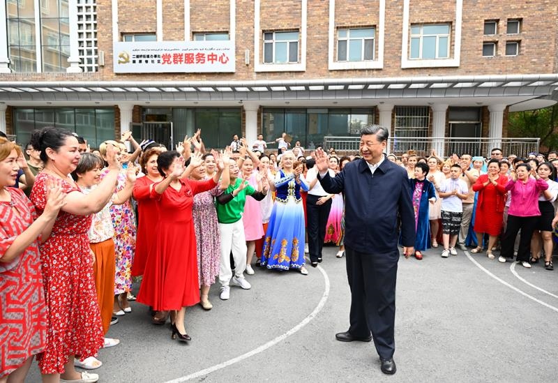 2022年7月13日，習(xí)近平總書記在新疆烏魯木齊市天山區(qū)固原巷社區(qū)考察時，向各族群眾揮手致意。