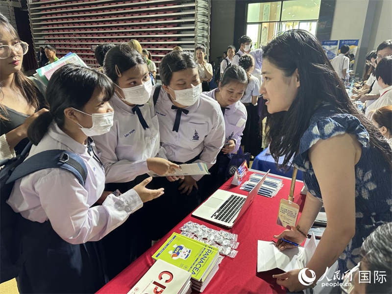 來自泰國的學(xué)生、家長在教育展臺前咨詢。人民網(wǎng)記者 簡承淵攝