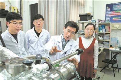 2017年10月，清華大學(xué)低維量子物理國家重點實驗室，薛其坤（左三）與學(xué)生討論實驗工作。 苑潔攝