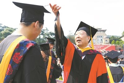 2017年6月22日，李德仁（右一）參加武漢大學(xué)畢業(yè)典禮并為畢業(yè)生撥穗。