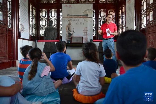 7月4日，在馬耳他桑塔露琪亞市的中國古典園林“靜園”，人們聆聽關(guān)于兵馬俑的講解。新華社發(fā)（喬納森·博格 攝）