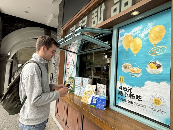 來自德國的留學生理查德在杭州西湖邊一家商鋪使用支付寶掃碼支付（2024年4月11日攝）。新華社發(fā)