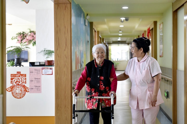 2024年5月25日，在山東省日照市東港區(qū)石臼街道日照幸福護(hù)理院，工作人員在陪護(hù)老人。新華社記者 郭緒雷 攝