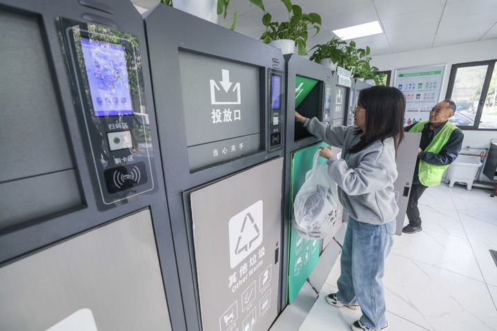 2024年4月10日，在浙江省湖州市吳興區(qū)飛英街道新華府小區(qū)內(nèi)，居民在垃圾分類智能系統(tǒng)的指導(dǎo)下進(jìn)行垃圾分類投放，居民的投放情況將實(shí)時(shí)匯總到智慧服務(wù)平臺(tái)，會(huì)有相應(yīng)的積分獎(jiǎng)勵(lì)。新華社記者 徐昱 攝