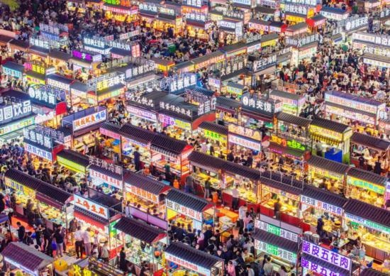 2024年4月21日，人們?cè)诤颖笔≌h小商品夜市品嘗美食（無人機(jī)照片）。新華社發(fā)（武志偉 攝）
