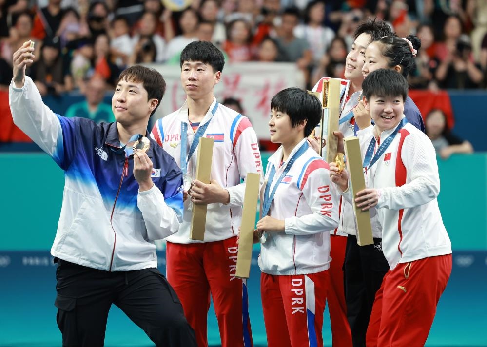 冠軍中國組合王楚欽（右三）/孫穎莎（右一）、亞軍朝鮮組合李正植（左二）/金琴英（左三）、季軍韓國組合林鐘勛（左一）/申裕斌在巴黎奧運(yùn)會(huì)乒乓球混雙頒獎(jiǎng)儀式上合影（2024年7月30日攝）。新華社記者 劉續(xù) 攝