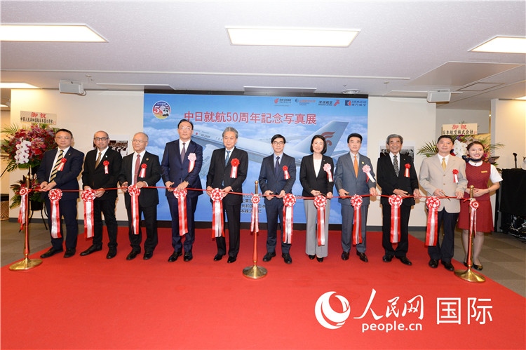 與會(huì)嘉賓共同為中日通航50周年紀(jì)念圖片展開(kāi)幕剪彩。馮學(xué)敏攝