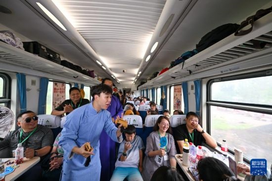 9月7日，相聲演員在S910列車上為旅客表演快板。
