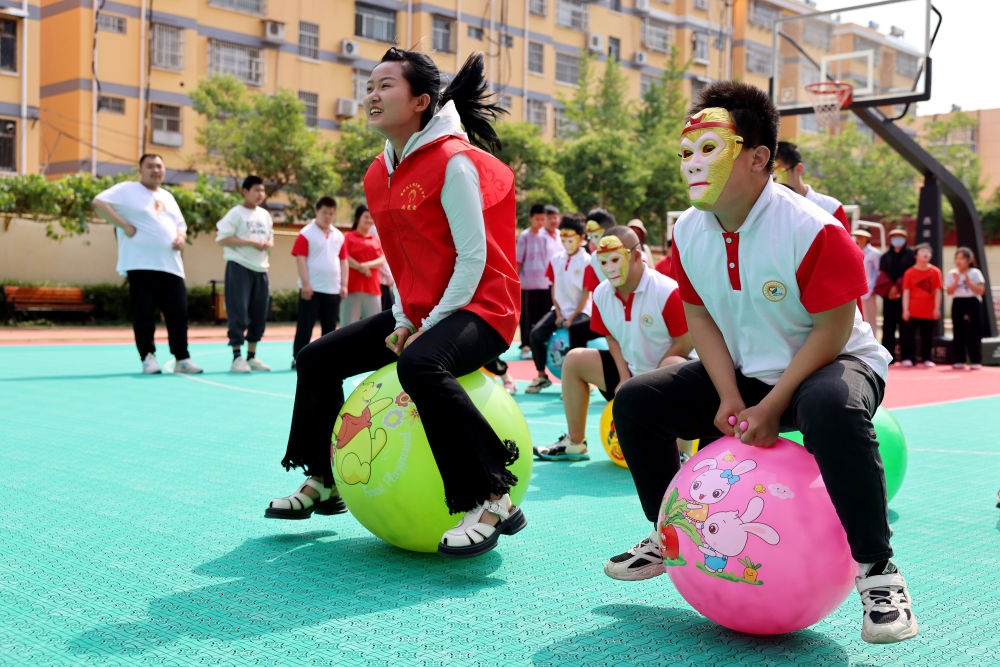 2024年5月17日，在山東省棗莊市市中區(qū)特殊教育中心，青年志愿者與智力障礙學(xué)生一起做游戲。新華社發(fā)（孫中喆攝）