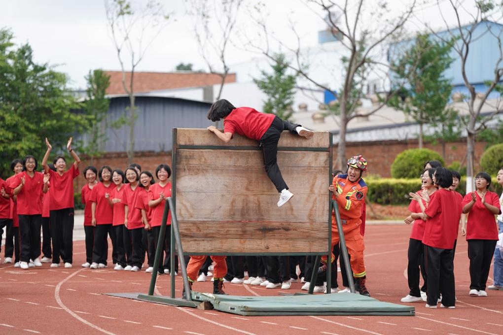 云南麗江華坪女子高級(jí)中學(xué)學(xué)生在體驗(yàn)翻越障礙板。新華社記者陳欣波 攝