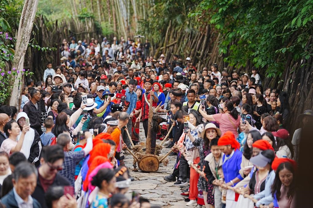 5月3日，各地游客在滄源縣翁丁村和村民一起參加佤族傳統(tǒng)民俗拉木鼓活動。（滄源縣融媒體中心供圖）