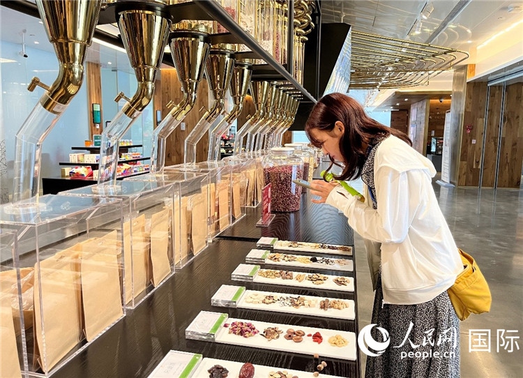 4. 代表團(tuán)團(tuán)員對(duì)新中式茶飲的食材充滿興趣。（人民網(wǎng)記者陳思 攝）