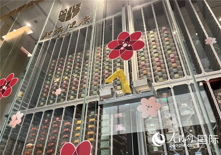6. 機(jī)械臂正在取貨。（人民網(wǎng)記者陳思 攝）