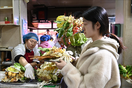 游客挑選好麻辣燙菜品后排隊(duì)等待加工。新華社記者 范培珅 攝