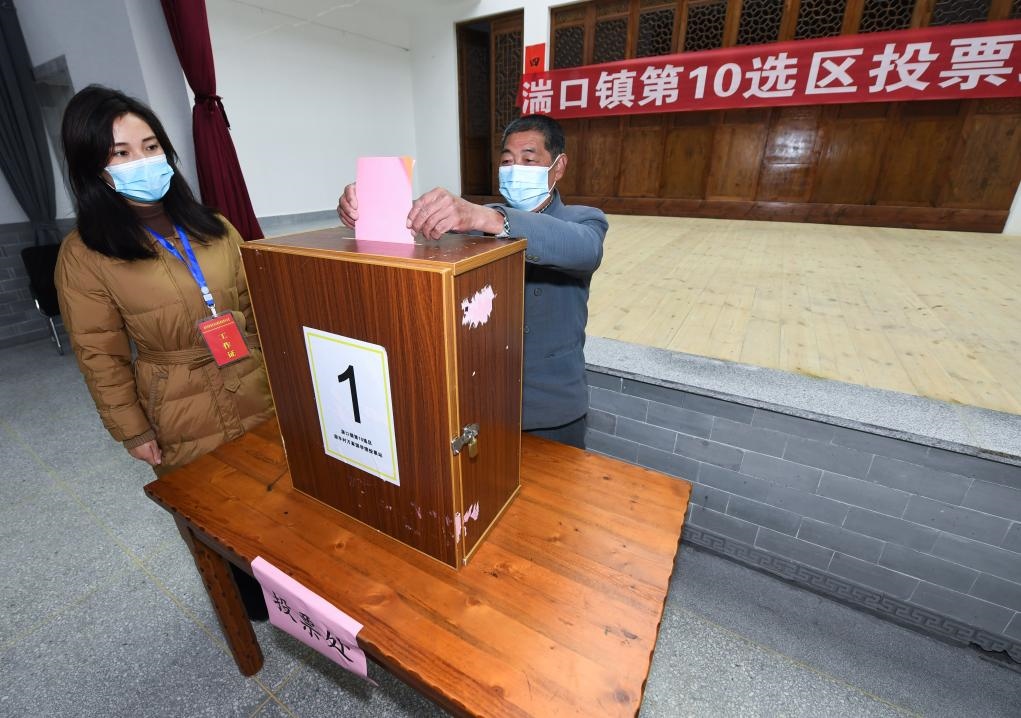 2021年12月14日，在浙江省杭州市臨安區(qū)湍口鎮(zhèn)迎豐村的基層投票點，村民在參加投票，村級監(jiān)察聯(lián)絡(luò)員監(jiān)票。新華社記者 徐昱 攝