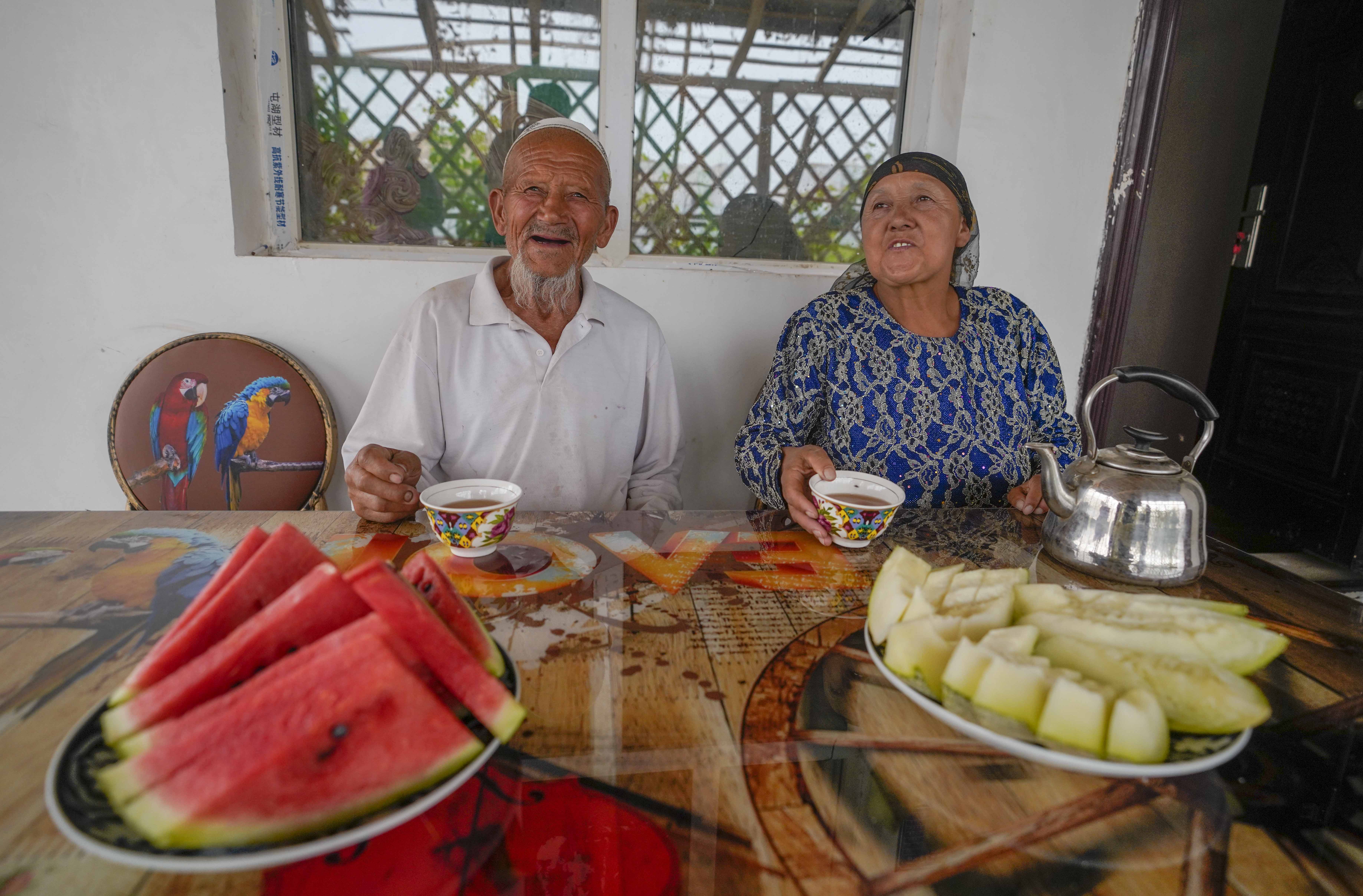 在新疆喀什地區(qū)伽師縣江巴孜鄉(xiāng)依帕克其村57號，80歲的維吾爾族老人伊米提·艾山（左）在自家庭院中（2020年6月8日攝）。