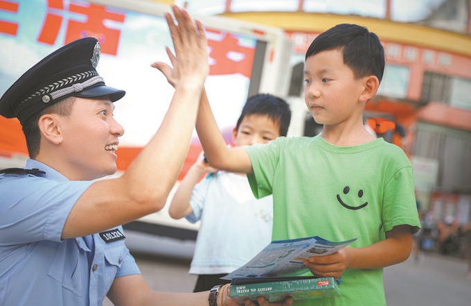 ▲7月10日，江西省吉安市公安局吉州分局組織民警深入轄區(qū)開展安全宣傳，民警向小朋友講解防溺水知識。朱文杰攝