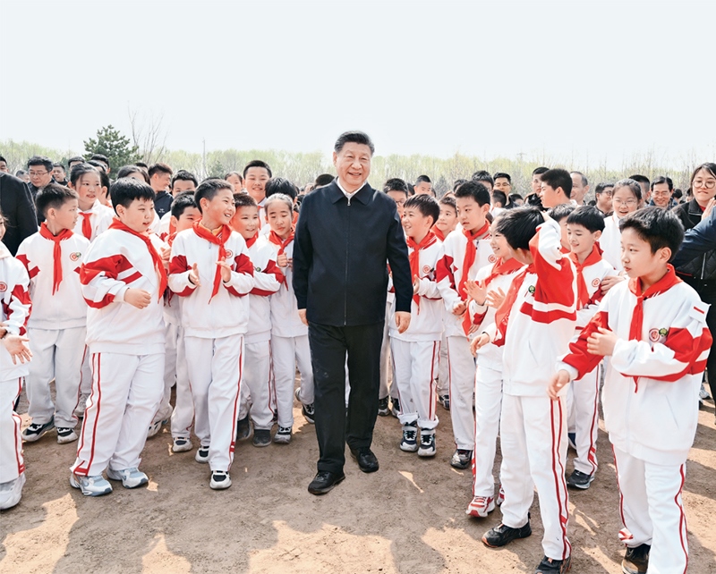 2024年4月3日，黨和國家領(lǐng)導(dǎo)人習(xí)近平、李強、趙樂際、王滬寧、蔡奇、丁薛祥、李希、韓正等來到北京市通州區(qū)潞城鎮(zhèn)參加首都義務(wù)植樹活動。這是習(xí)近平同少先隊員在一起。 新華社記者 李學(xué)仁/攝