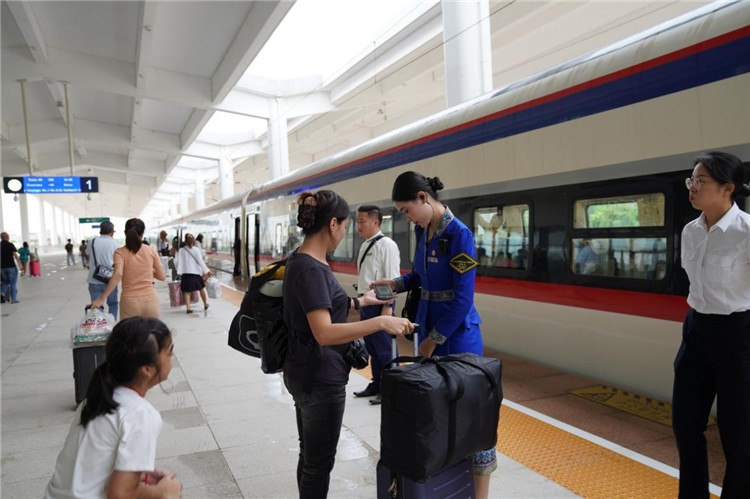 中老鐵路工作人員在站臺指引旅客進站乘車。老中鐵路有限公司供圖