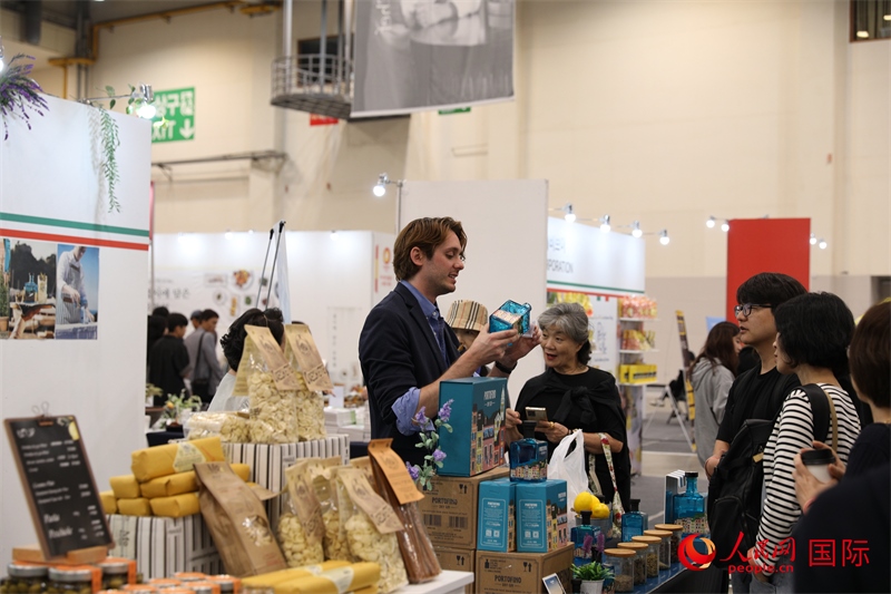 當(dāng)?shù)貢r(shí)間10月5日，在第21屆釜山國(guó)際美食博覽會(huì)上，意大利展商向參觀者們介紹的意大利食品。人民網(wǎng)記者 莽九晨攝
