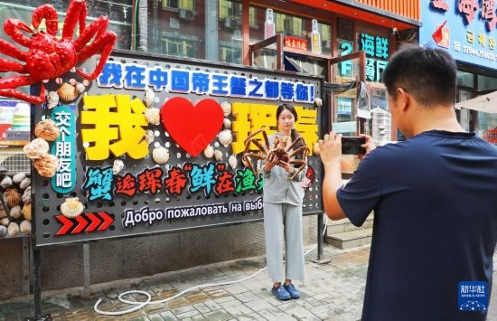 9月21日，游客在吉林省琿春市一處帝王蟹元素主題裝飾前拍照留念。新華社發(fā)